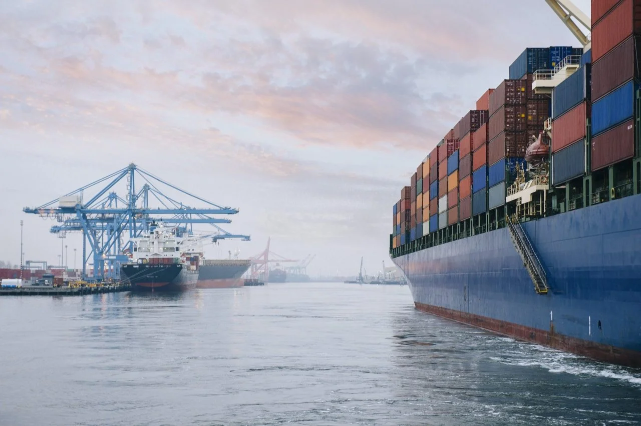 Loaded container ship at a busy cargo port with cranes